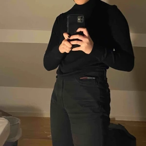  - Svart polo i merinoull. Sitter snyggt tight över kroppen!  Klassisk turtleneck. 