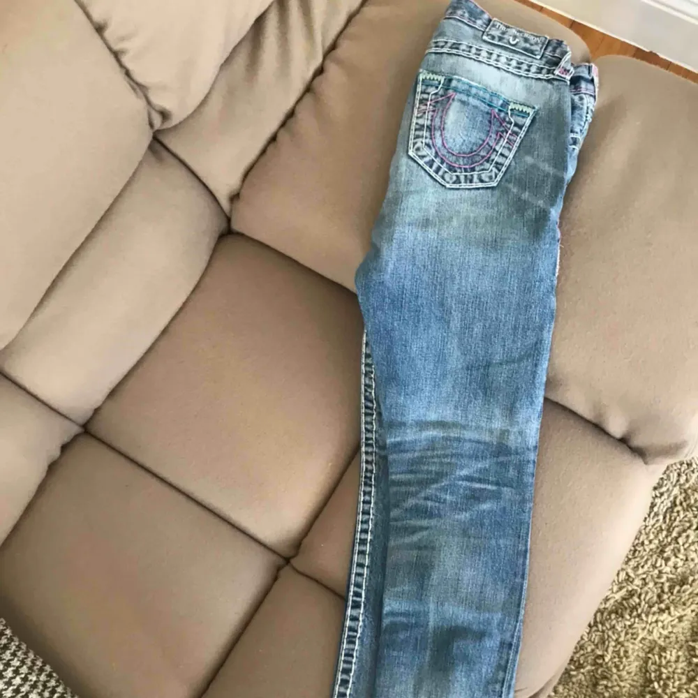 Ett par balla True Religion jeans. Ljusblå med vita och lila sömmar. Strl 24. Straight jeans. Låg midjade, passar kvinnor/ tjejer som är upp till 170cm. Köpte i Miami 2016, väldigt bra skick!. Jeans & Byxor.