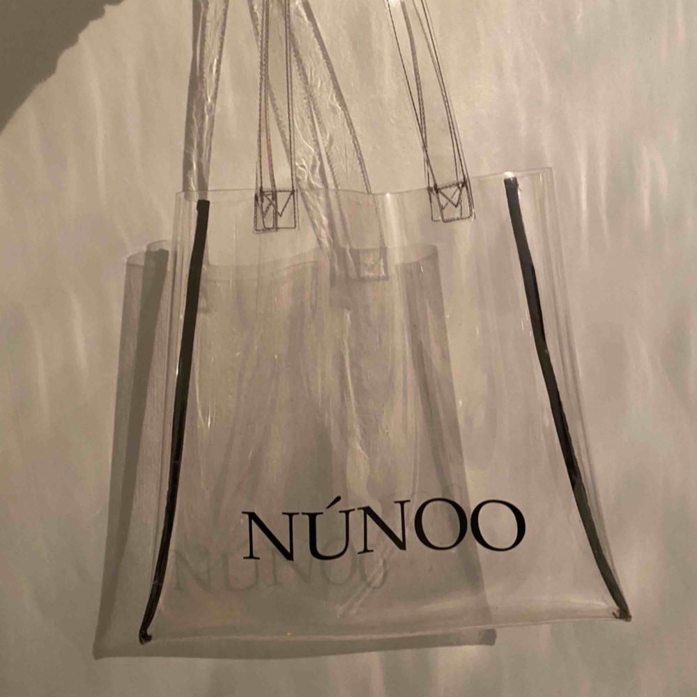 Genomskinlig väska från Nunoo. Väldigt fin!! Original pris: 349kr. Mitt pris 159kr Köparen står för frakten. Väskor.