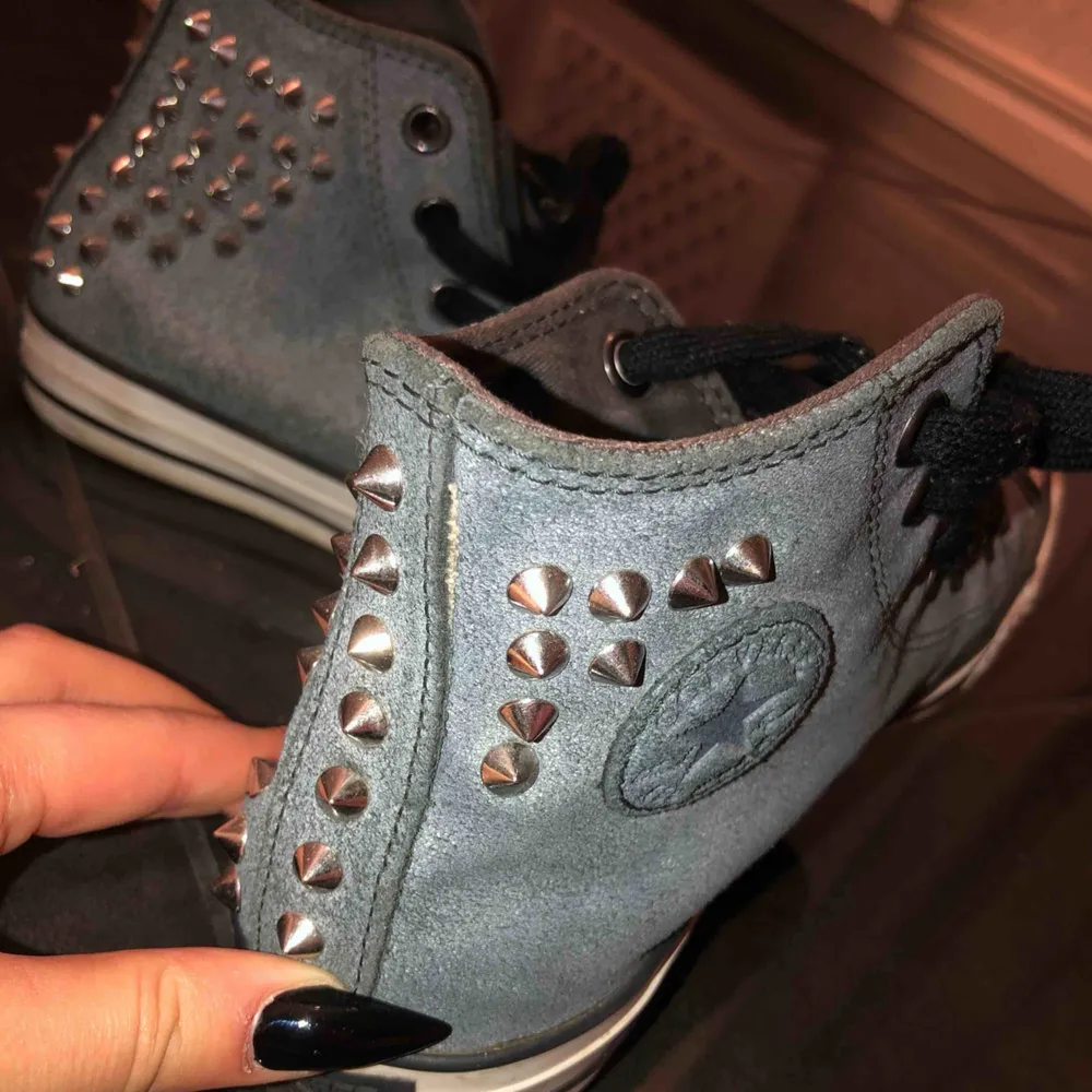 Ett par grå svarta höga Converse med silver nitar bakre delen av skorna, köpta för snart tre år sen men använda bara två gånger. Jättefina, unika och i bra skick!. Skor.
