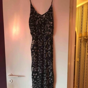  - Jumpsuit med blommigt mönster. Ej stretchig. Knappt använd.  Betala gärna med swish. Frakt blir 35 kr. Kan samfrakta om du köper flera varor av mig!