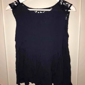  - Marinblå blus med spets på ryggen. Nästan aldrig använd, XS från Vila. Kontakta om du är intresserad!