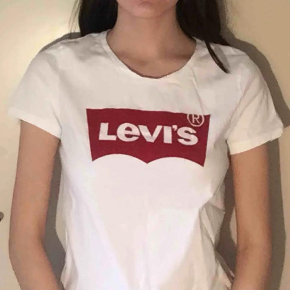 Basic vit Levi’s t-shirt, storlek XS. Längden av t-shirten går ner till under höfterna. > ALLA KLÄDERSOM KÖPS, TVÄTTAS OCH STRYKS INNAN SÄNDNING.. T-shirts.