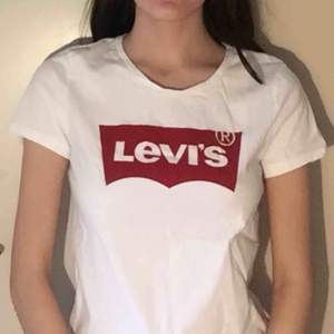 Basic vit Levi’s t-shirt, storlek XS. Längden av t-shirten går ner till under höfterna. > ALLA KLÄDERSOM KÖPS, TVÄTTAS OCH STRYKS INNAN SÄNDNING.