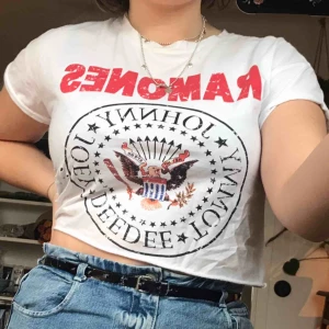  - Vit och kort t-shirt med Ramones loggan på, lite ripped (köpt så). Köpt på Bershka i storlek S. Knappt använd.