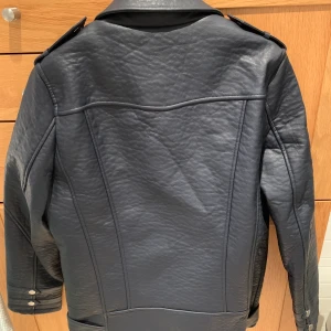 Skinnjacka - Oversized skinnjacka (läderimitation) i mörk marinblå. Aldrig använd och prislappen är kvar. Nypris 2079kr.