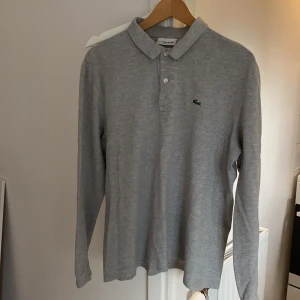 lacoste piké grå - grå lacoste piké. använd några gånger. mycket bra skick! 