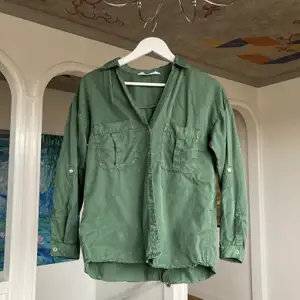 Militärgrön skjorta i skönt material i storlek XS. Lite svårt att fånga färgen på bild men den första bilden stämmer bra överrens! Köparen står för frakt!
