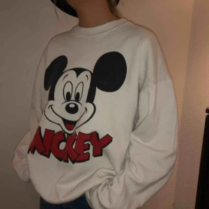 - Vit vintage Mickey Mouse sweatshirt med droppade axlar, snygg oversize fit och crewneck. Köpt på blocvintage och är ett original exemplar från disney.