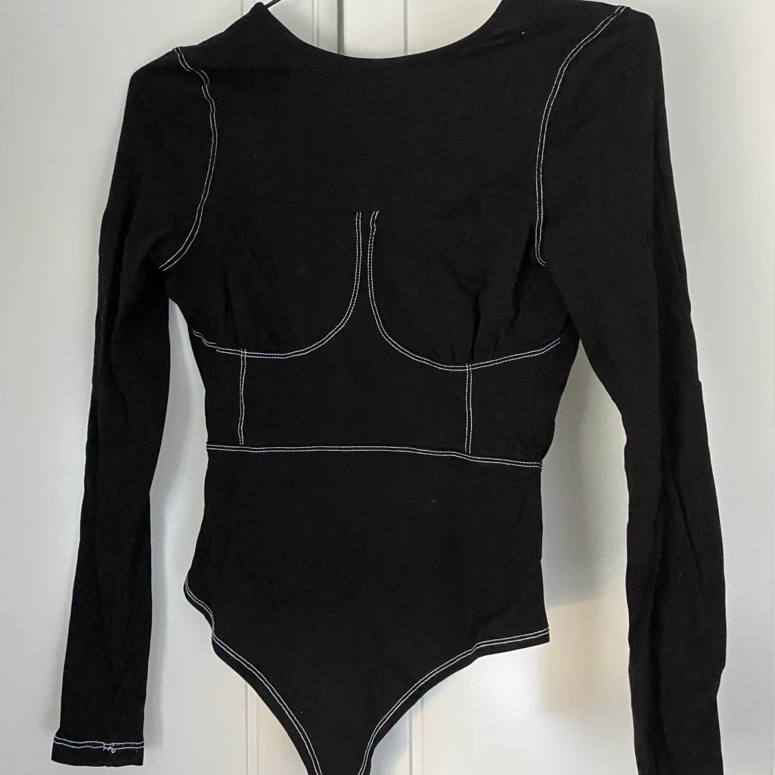 Frän, svart body med kontraststygn från Nelly