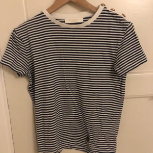 Busnel t-shirt randig strl.36 - Väldigt bra kvalité pga att den knappt använts. Köptes för 2 år sedan och kostade ny ca 1300kr men kommer inte ihåg exakt eftersom den inte säljs längre. Den är väldigt skön och helt gjord i äkta bomull. Den har 3 kända Busnel knappar på vänstra axeln och märket nere till vänster. Frakten ingår i priset😊