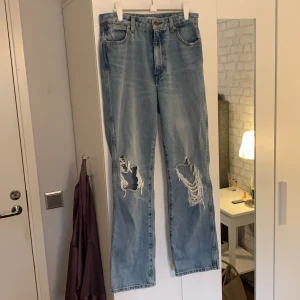 Wrangler jeans - Grymt snygga jeans från Wrangler med rejäla slitningar, storlek 27/32! Jag skulle säga att dom är lite små i storleken då jag själv brukar ha 27 i midjan men tycker dessa sitter lite för tajt på mig, det är därför jag säljer dom. Endast använda 2 gånger. Ena fästet på en hälla har släppt, men det går lätt att sy ihop om man vill det! 👖