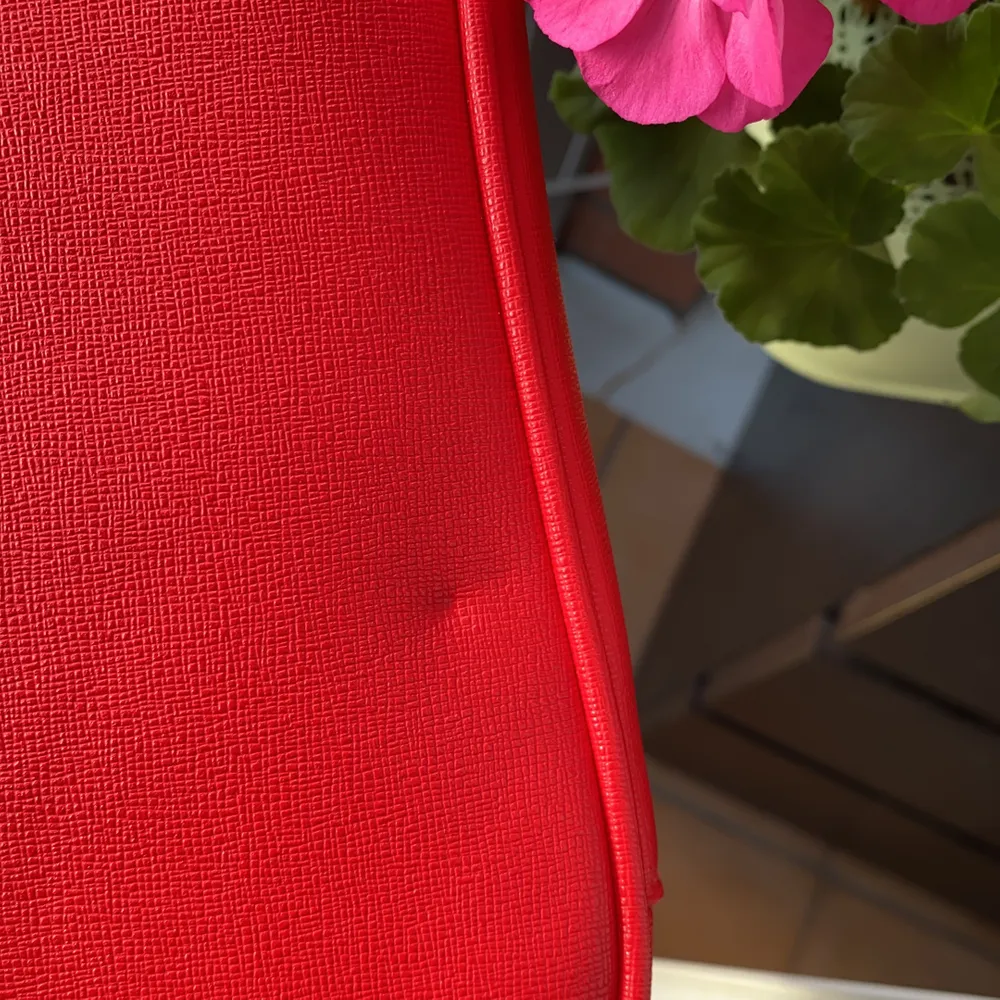 Supersnygg och trendig röd axelväska där ett längre band medföljer som är justerbart. Har endast använt 2 gånger och har en knappt synligt liten inåt buckla. Säljes för 175kr inkl frakt🌟. Väskor.