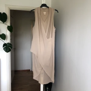 Wrapdress från H&M - Superfin klänning från H&M, storlek 34. Draperande, längre bak och kortare fram med en underklänning som grund. Köparen står för ev fraktkostnad 🥰