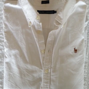  - Vit skjorta från Ralph Lauren. Använd 2-3 gånger. Tyvärr en liten fläck på ena armens undersida, men som bör gå att få bort i tvätten. Mycket bra skick för övrigt. 