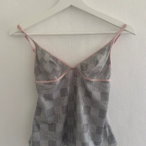 Vintage Triumph linne - 💕Jätte gulligt linne från Triumph. Mönstrad med rosa detaljer och en plastdiamant i mitten. Justerbara band. I baddräktsmaterial. Har ägt det i många år men inte kommit till användning och nu är den för liten. Köparen står för även för frakten som ligger på 22 kr, jag kan även göra paketet spårbart men då ligger frakten på 49 kr. 😊