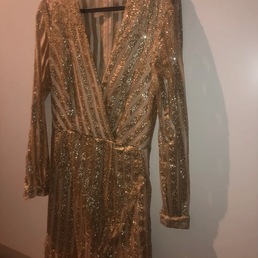 Guldiga glittrig klänning som är köpt på nelly.com.      Använd 1 gång. Perfekt nyårs klänning eller för finare tillfällen! Frakt tillkommer.. Klänningar.