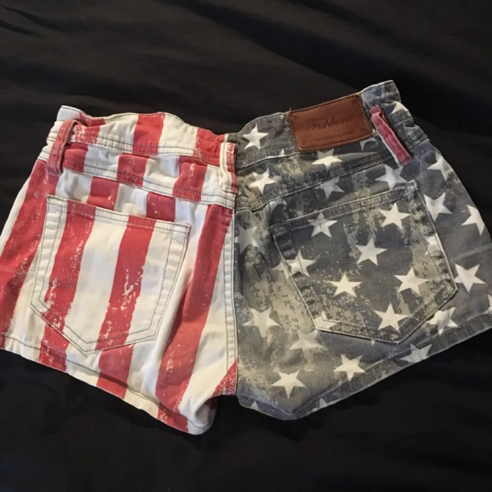 Ett par låga shorts som föreställer den amerikanska flaggan Frakt står en för själv. Shorts.