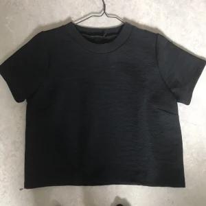  - Svart T-shirt i med lite hårdare tyg. i stl m 