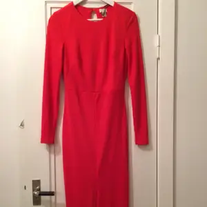Elegant röd maxiklänning. Slits framtill och öppen rygg med en knapp i nacken. Passar perfekt till bröllop eller fest