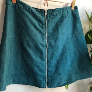 Mockakjol med dragkedja - Toksnygg kjol i turkos/petrolfärgad mocka. Använd men i mycket gott skick. Ganska liten i storleken, passar dig som är M/38-40! Köparen står för frakten ✨