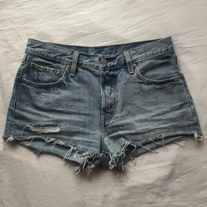 Levis jeansshorts  - Jeansshorts från Levis i nyskick! Knappt använda pga för liten storlek. Superfin ljus tvätt med snygga slitningar. Klassiska modellen 501. Köptes för ett år sedan för 550kr. 