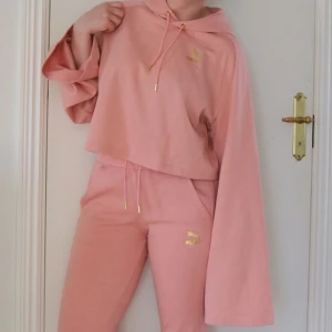 Kenza x Puma - rosa hoodie - Rosa hoodie/träningströja från Kenzas kollektion med Puma med gulddetaljer. Sparsamt använd och i mycket fint skick. Vida ärmar och är en kort modell. Luftig och skön. 