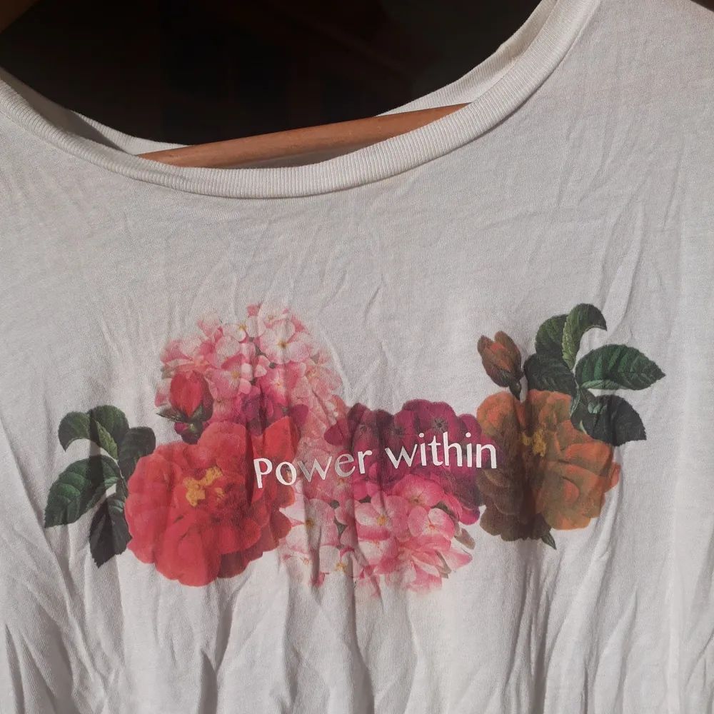 Gullig t-shirt med blommor på och texten 