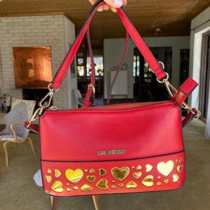 ❤️Love Moschino Väska❤️ - Super fin röd väska med guld detaljer från Love Moschino, kommer med dustbag! Använd två gånger. Rymmer mycket utan att se klumpig ut och älskar färgen❤️ buda gärna, köptes för 1100kr❣️