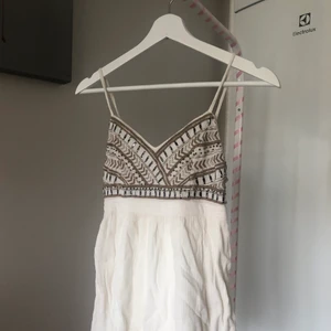 Linne topp - Jätte fin topp från Hollister. Är i linne liknande material och har fina pärlor och mönster detaljer. Banden är justerbara på längden, storlek xs. Nypris ca 150kr