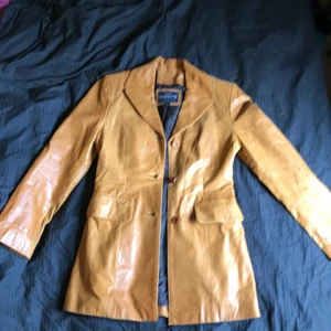Skinnjacka  - Lite längre, figursydd jacka i ljust läder. Bra skick.
