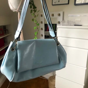 Blå söt handväska - As gullig handväska köpt här på plick, säljer då den inte kommer komma till användning. Passar perfekt till sommaren.🥰🥰 Den har några slitningar, men inga som påverkar funktion (be om bild) ‼️Frakt ingår i priset‼️