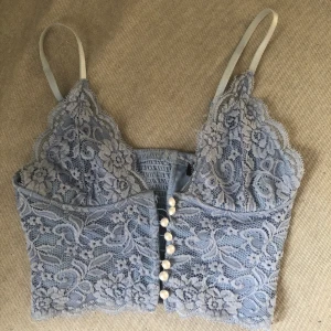 spets topp - en skitsnygg spets topp från bikbok! en knapp har lossnat men enkelt att sy fast, jätte skön å fin nu till sommaren! säljer för den har blivit liten<3