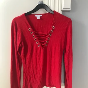 Tröja med snörning - En fin röd tröja med snörning, köpare står för frakt