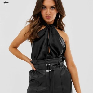  - Body i string med omlott fram och knytning i halsen! Superfin djup öppen rygg! Glansigt svart ”silkesmaterial”. Så snygg till fest! Helt oanvänd eftersom den inte passade 100%! Slutsåld på ASOS!🤍🤍 köparen står för frakt!