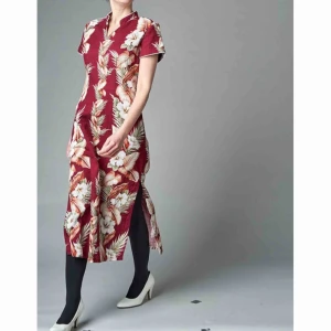 Hawaii-klänning - En hawaii-klänning med kinakrage. Slits i båda sidor, axelvaddar och vit passpoal runt ärm och krage. Mäter 116 cm från axel. 