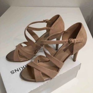  - Helt nya, oanvända klackar i färgen nude. Snygga och sköna på foten, perfekta för fest/bröllop/studenten/vår/sommar. Klackhöjd ca 10 cm.