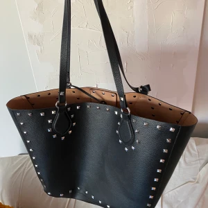 Svart shopper väska  - En mellanstor svart shopperväska med nitar från Zara. Insidan är beige och har även ett ”löst” innerfack (se bild). Riktigt fint skick! Frakt tillkommer.