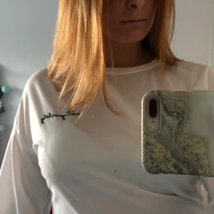 Vit långärmad tröja - Vit långärmad tröja men svarta knytningar vid ärmarna. Svart text vid vänster sida av bröstet. Skriv privat för bättre information💞