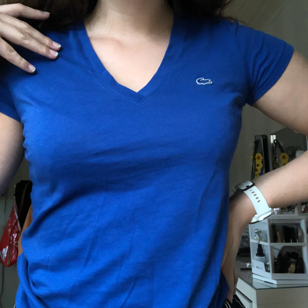 Snygg V-ringad t-shirt från Lacoste. Riktigt härlig färg på tröjan, men kommer tyvärr inte till användning. Tröjan är i strl 36, men sitter bra på mig som är en 38/40!! 💛💛. T-shirts.