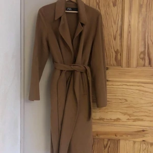 Tunnare Ullkappa Zara som Ny!! - Helt oanvänd kappa från Zara , storlek small kostade 1299 ny och den är använd en gång. Jättefin och bekväm men tyvärr lite stor för mig då jag är en XS och detta är en S - buda vid fler intresserade!