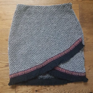 Kjol - Omlottkjol med fransar från New Yorker. Aldrig använd. Säljes då den är för liten. Storlek 34. Frakt ingår. 