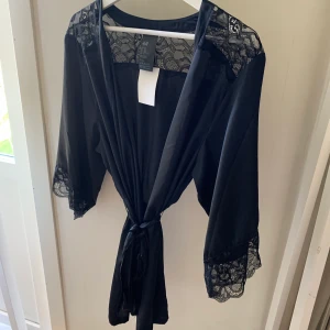 En spetsig kimono - En svart kimono med spets vid ärmarna och vid ryggen. Använd 1 gång + prislappen finns kvar. Storlek M/L men skulle säga att den är S eftersom jag är det i vanliga fall.  Tvättar plagget innan säljning. Frakten står köparen för. Skriv om ni har några funderingar !!🤍💓🌸 