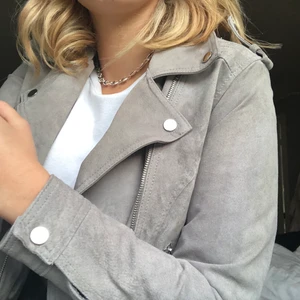 Mocka jacka - Grå mockajacka med silverdetaljer. Aldrig använd så mycket bra skick. Figursydd i ryggen vilket framhäver dina former. Lite svår att ha tjocktröja under då den är ostretchig. Frakt: 60 kr