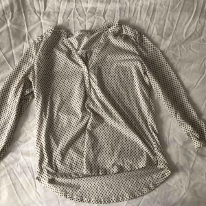  - Prickig blus med knappar fram och lite längre bak