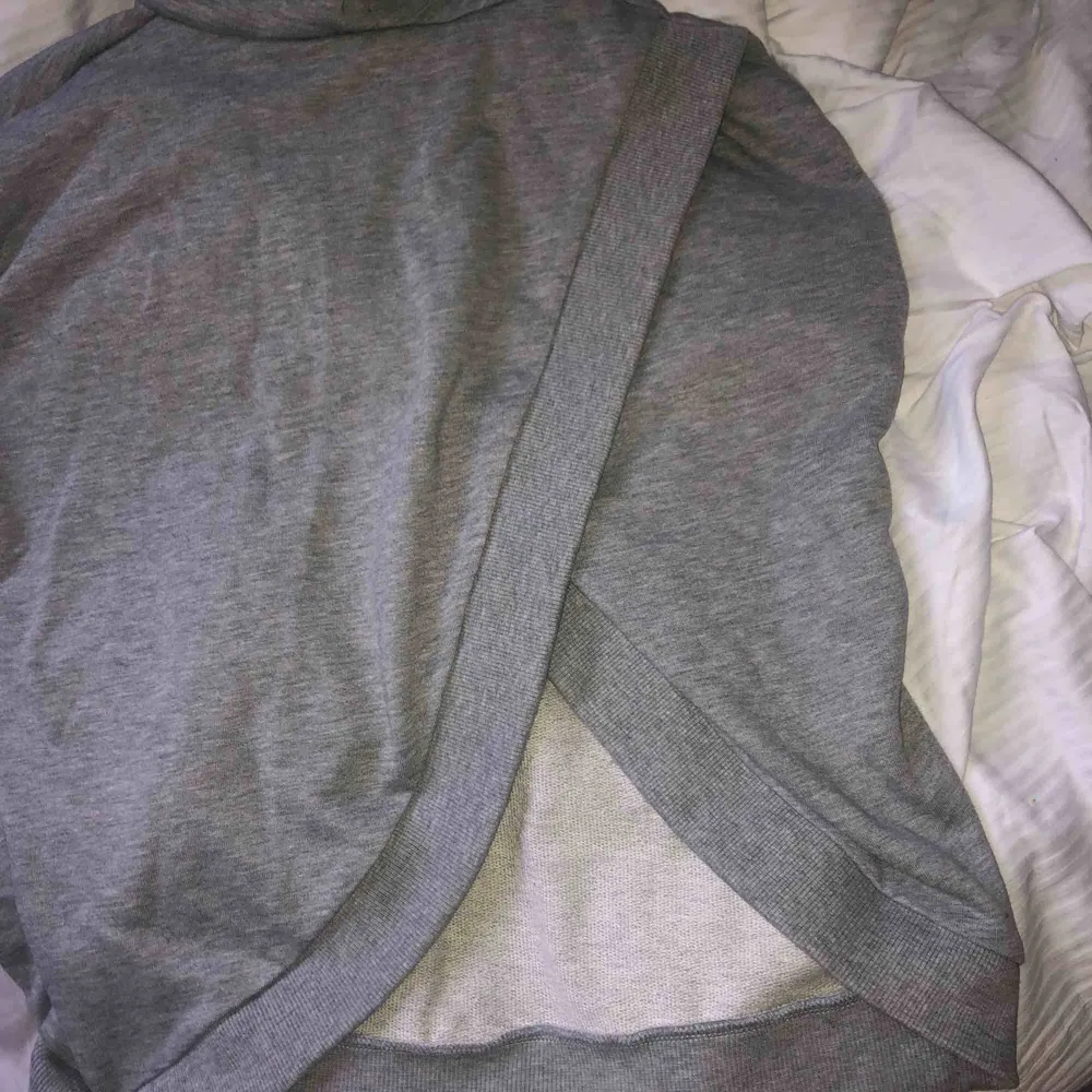 En grå hoodie med slits på ryggen. Har använt ungefär två gånger, bra skick. Frakt ingår ej i priset. . Hoodies.