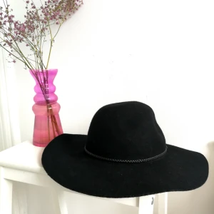  - Svart hatt med ganska stor skärm, rundad på huvudet 🌼