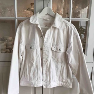  - Snygg vit jeansjacka med snörning på ryggen från H&M i storlek 38! 