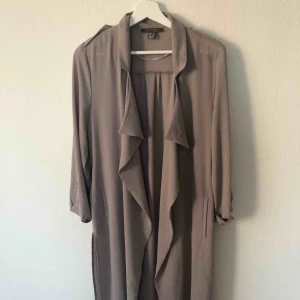  - Tunn lång kappa med band i midjan.  Jätte fin färg och snygg på.  Knappt använd. Storlek M 