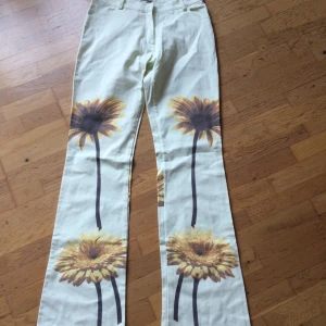 90s byxor - Inser att det är dags att släppa taget om dessa fina byxor då jag inser att jag aldrig kommer bli så smal igen 😅 Beiga byxor med stora blommor, utsvängda nertill. Köpta i Berlin i början av 90talet. Stl M. Priset är inkl vanlig frakt 🌻